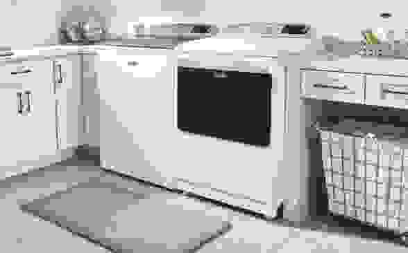 A white washing machine and dryer sit in a laundry room