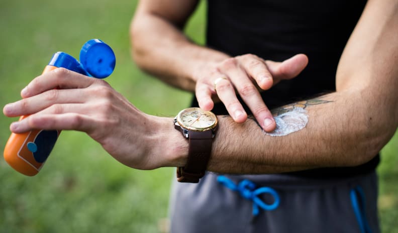 Man applying sunscreen hiking