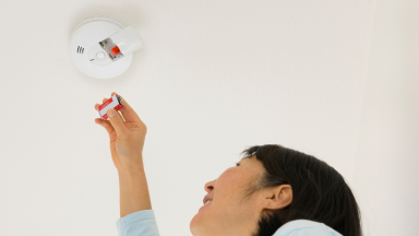 Person replacing battery of a smoke detector