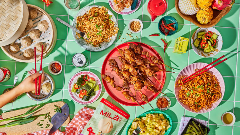A colorful spread of various Mila foods, including dumplings, noodles, and more
