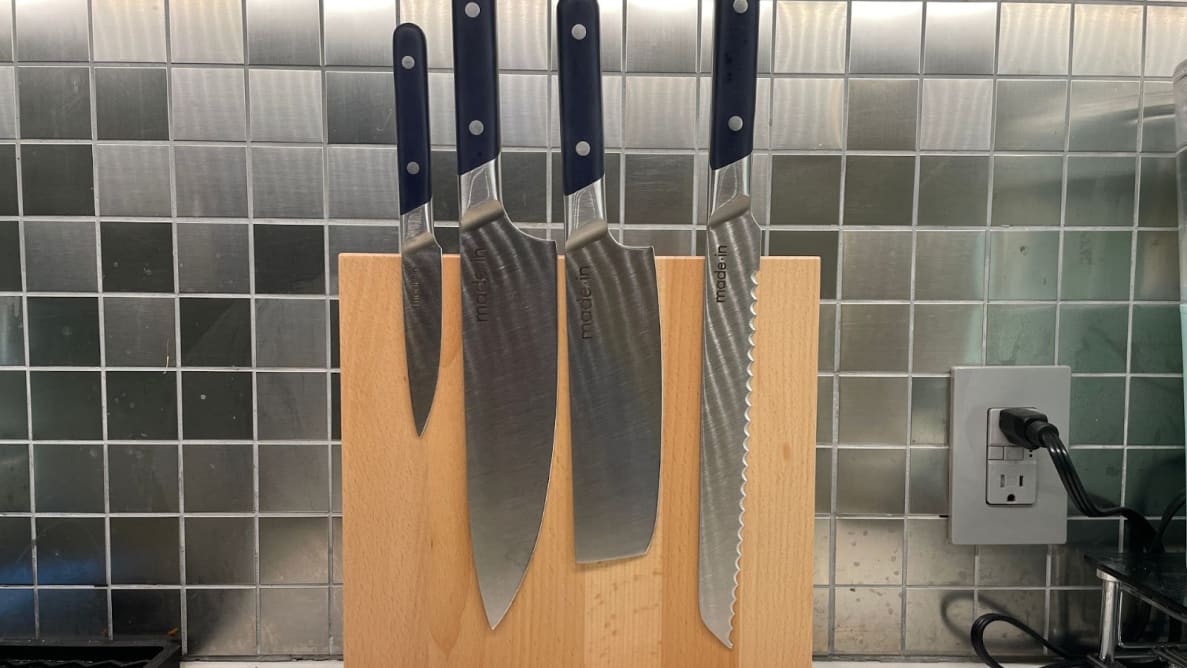 Four-piece Made In Knife Set placed against a wooden magnetic block in front of tiled kitchen wall.
