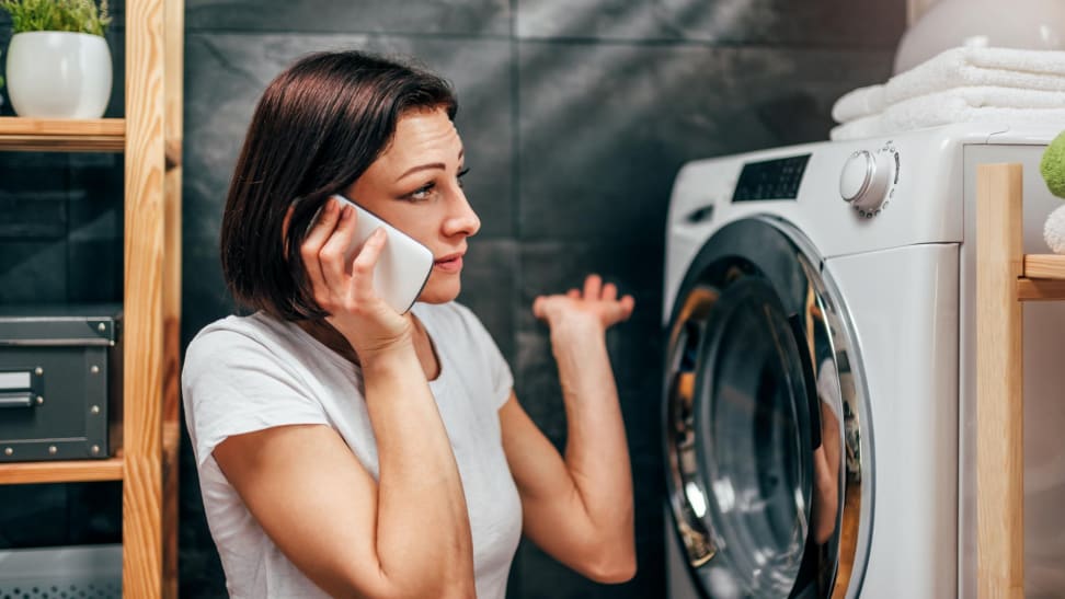 Woman on the phone standing next to washer