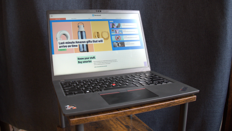 Lenovo ThinkPad P14s Gen 4 opened up with internet browser on screen in front of navy blue curtain.