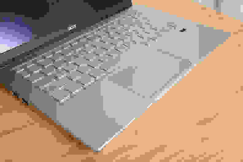 A laptop keyboard sitting on top of a light brown surface