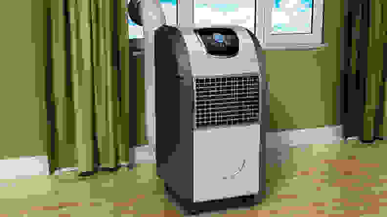 A portable air conditioning unit in front of a window.