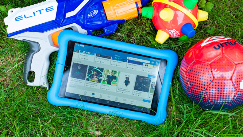 Amazon Fire Tablet for kids sits on the ground next to toys for kids