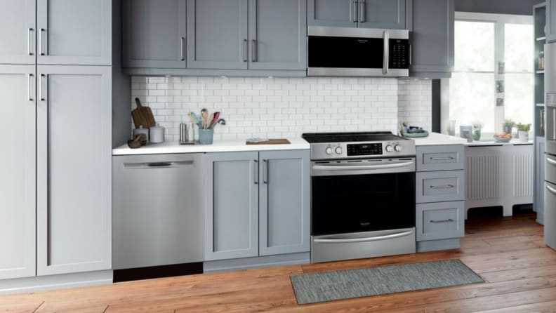 A sleek, modern kitchen with light grey cabinets and a stainless steel range.