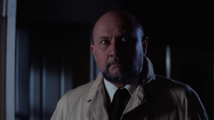 Sam Loomis (Donald Pleasence) searches a dark house for his former patient, Michael Myers, in ‘Halloween.’