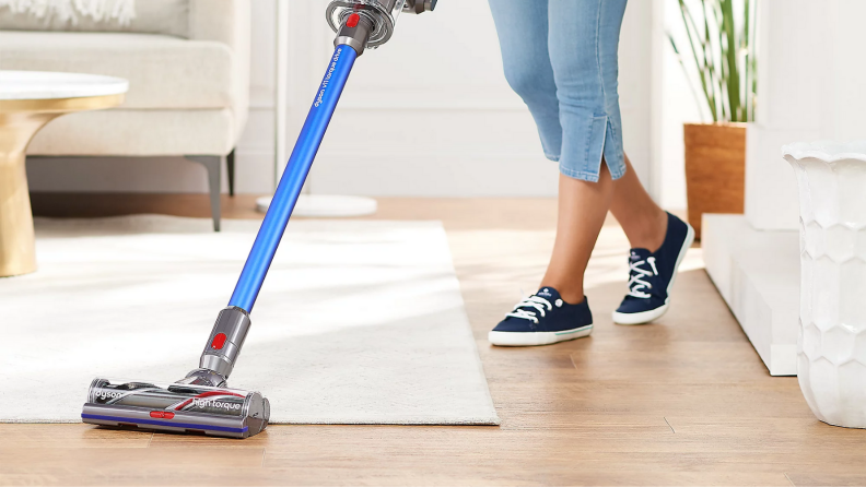 An image of a Dyson vacuum moving over a wooden floor.