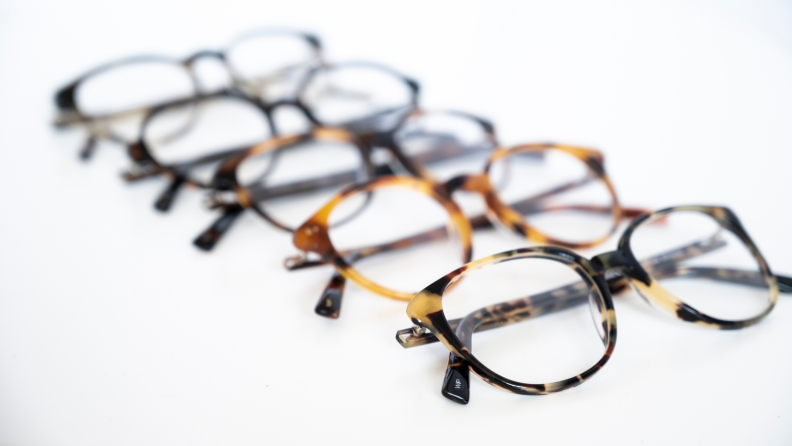 An image of 5 eyeglasses laid out in a row.