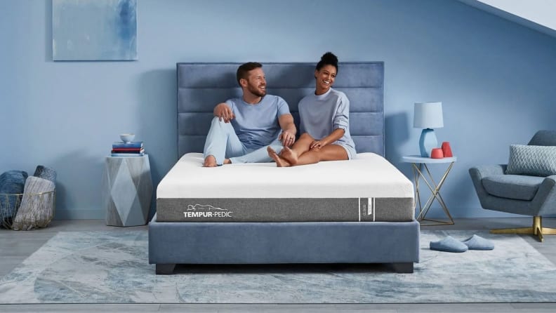 a couple sits on the tempur-pedic mattress