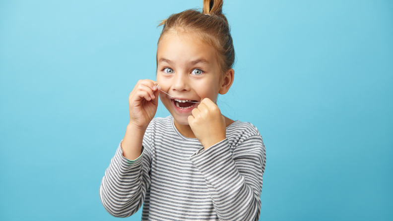 Girl flossing her teeth