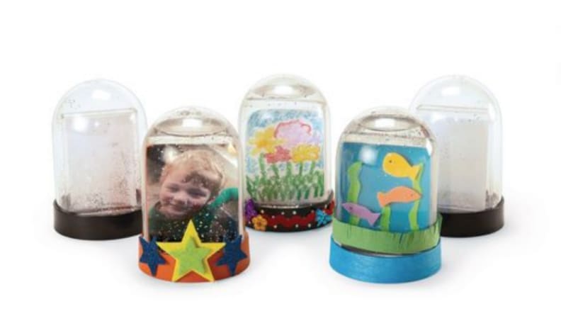 Five plastic snow globes with different pictures and drawings inside.