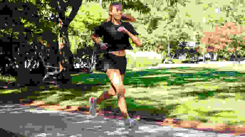 A person runs in a park wearing Janji shorts.