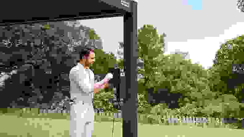A man sitting under a FlexPatio motorized pergola