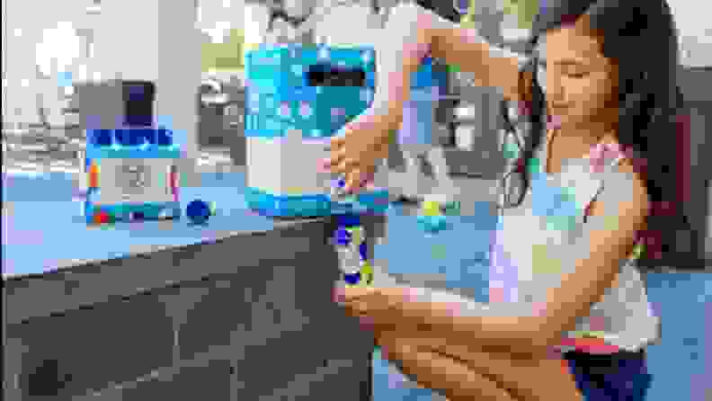 A child refills her bubble solution bottle from a spout