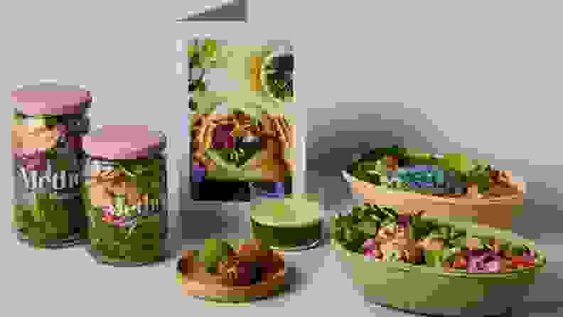 Various jars and containers of food laid out on green background