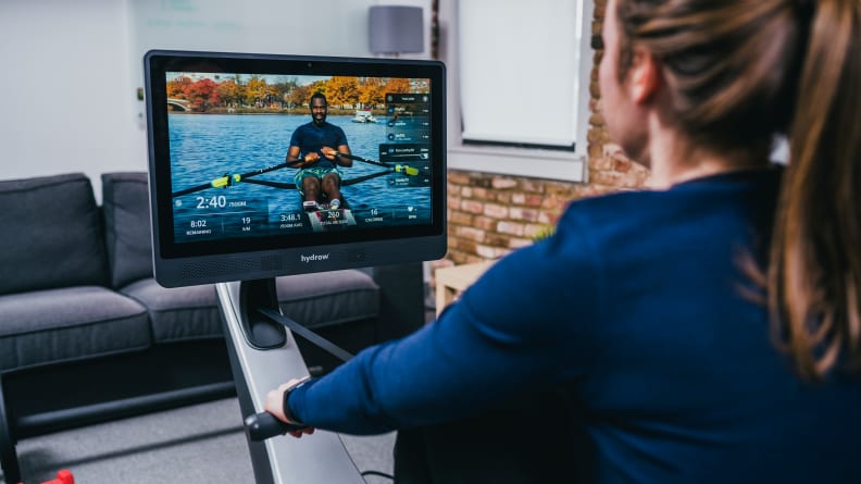 Woman working out on Hydrow rowing machine.