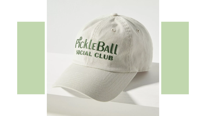 A white baseball cap embroidered with the words "PickleBall Social Club" in green thread.