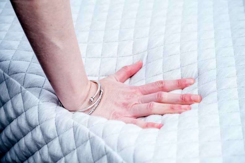 a hand presses into the Leesa Hybrid surface