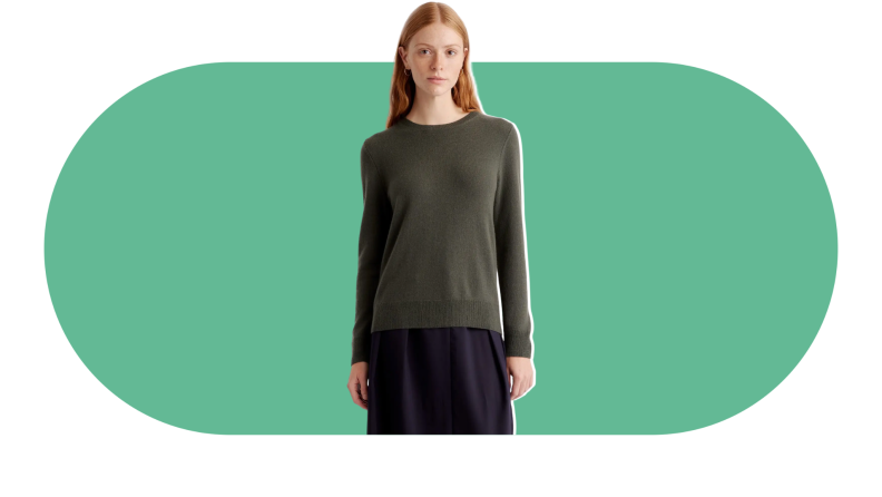 A model wearing a dark green long-sleeved cashmere sweater.