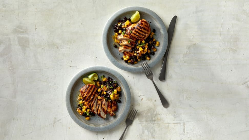 A healthy meal with chicken and more on a gray background.