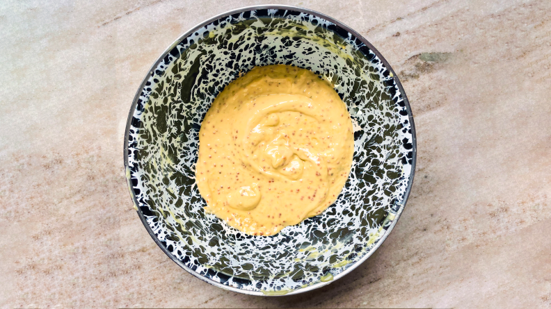 A blue speckled bowl of dijonnaise.