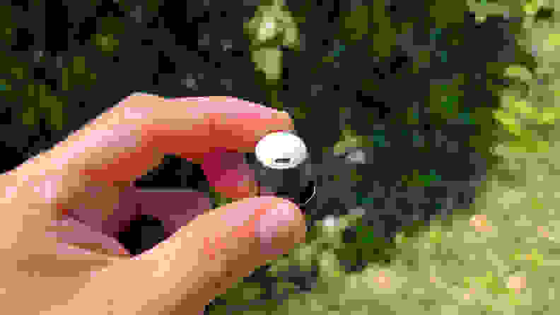 A mint green Pixel Bud Pro held in the fingers.