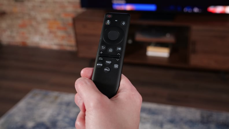 A person holding the Samsung S95C remote.