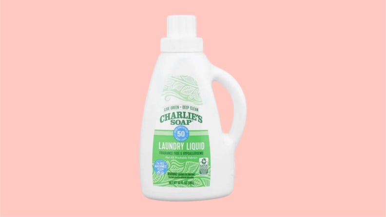 A bottle of Charlie's Soaps laundry detergent on a pink background.