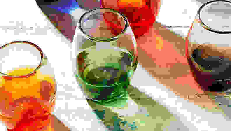 wine glasses with colorful bottoms on greyish counter