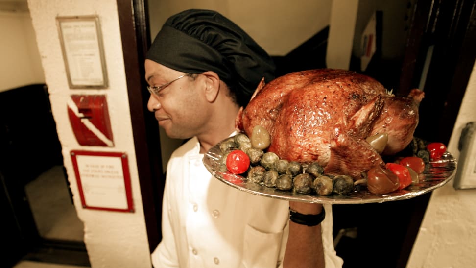 Assistant Chef Joe Breaton carries out a turkey prior to actor Stephen Baldwin serving Thanksgiving dinner to men and women at the New York City Rescue Mission on November 23, 2004 in New York City.