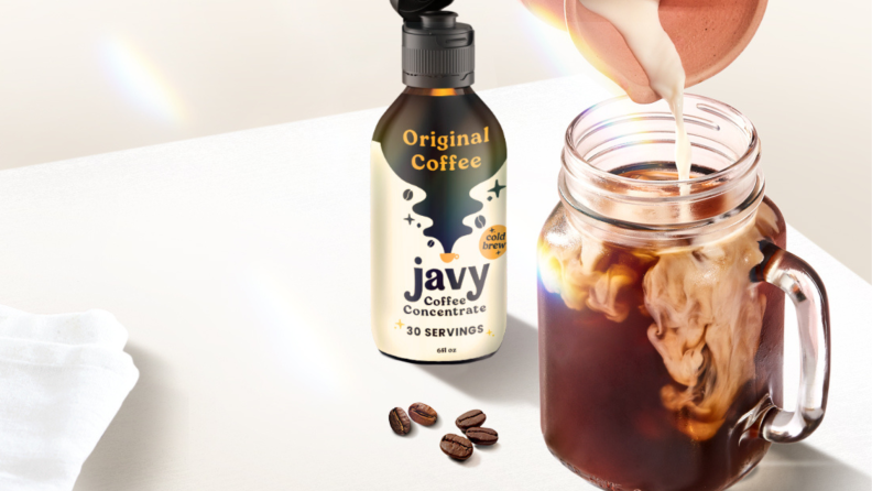 Javy coffee concentrate bottle beside a glass mug of coffee