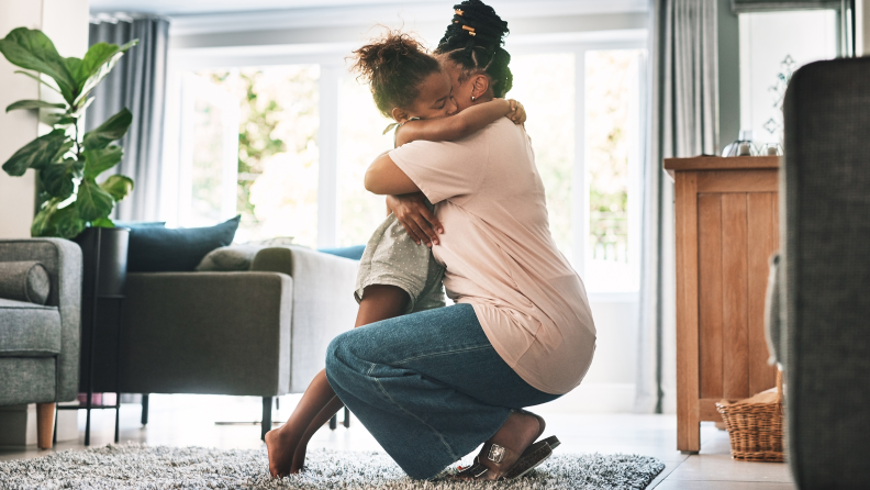 A Black mother hugging her child