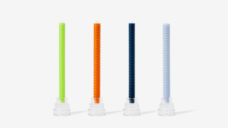 Four multicolored candles against a white background