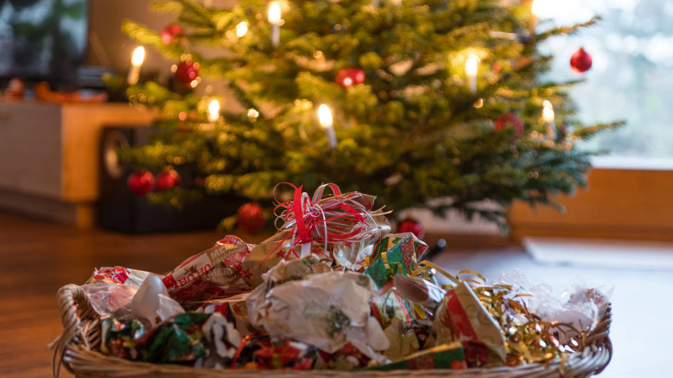 A basket of trash sitting in front of a Christmas tree