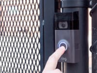 A person pressing a Ring Video Doorbell