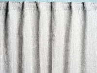 A set of gray curtains hanging from a rod against a blue background