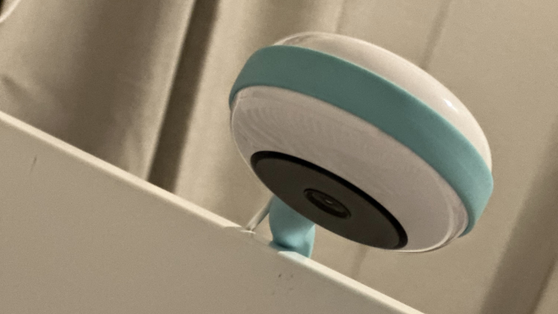 Lollipop Smart Baby Camera in turquoise and white color angled downwards over baby crib.