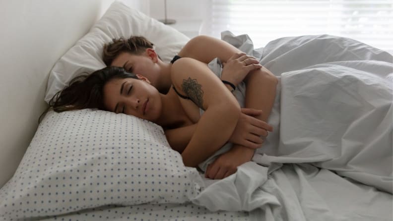 a couple asleep spooning