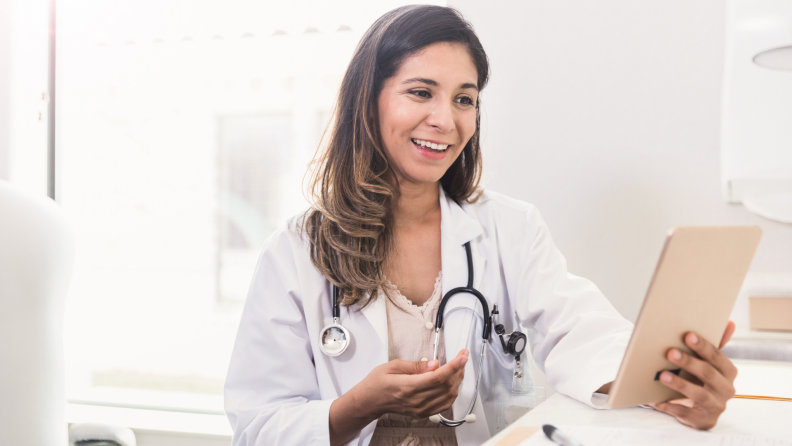 A doctor consults with their patient remotely.