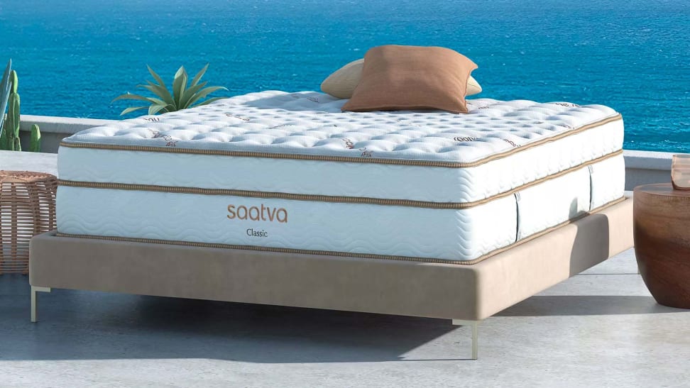 A Saatva mattress outside on an ocean background.