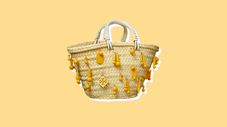 Photo of the Tory Burch Small Raffia Tote Bag against a yellow background.