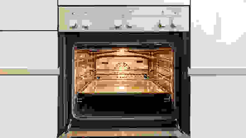 A stainless-steel oven with the interior light turned on.