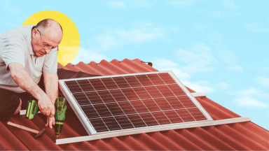 Man using drill to secure solar panel to brown roof against a blue sky.