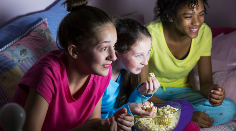 Three tween girls watch TV