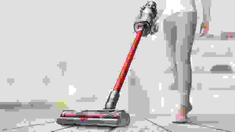 Woman using red and purple Dyson vacuum