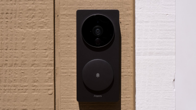 The Aqara Smart Video Doorbell G4 hanging on the side of a home