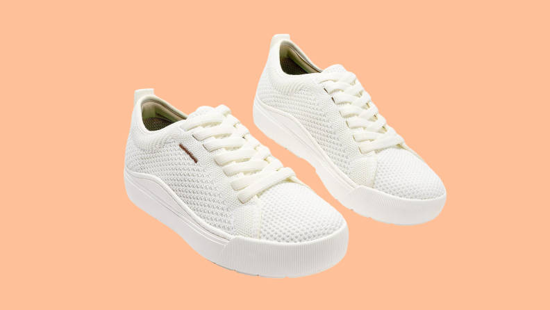 white mesh sneakers on orange background