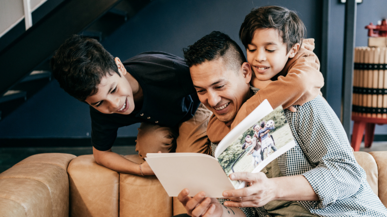 A parent shows children a family photo album.